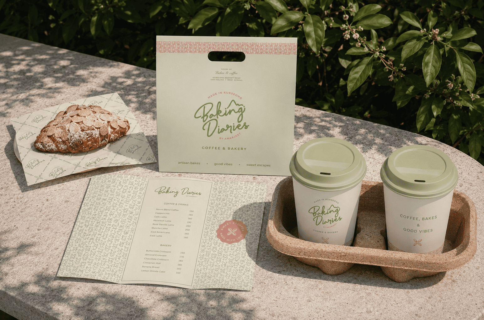 Baking Diaries branded takeaway bag, menu and coffee cups on a caf&eacute; table