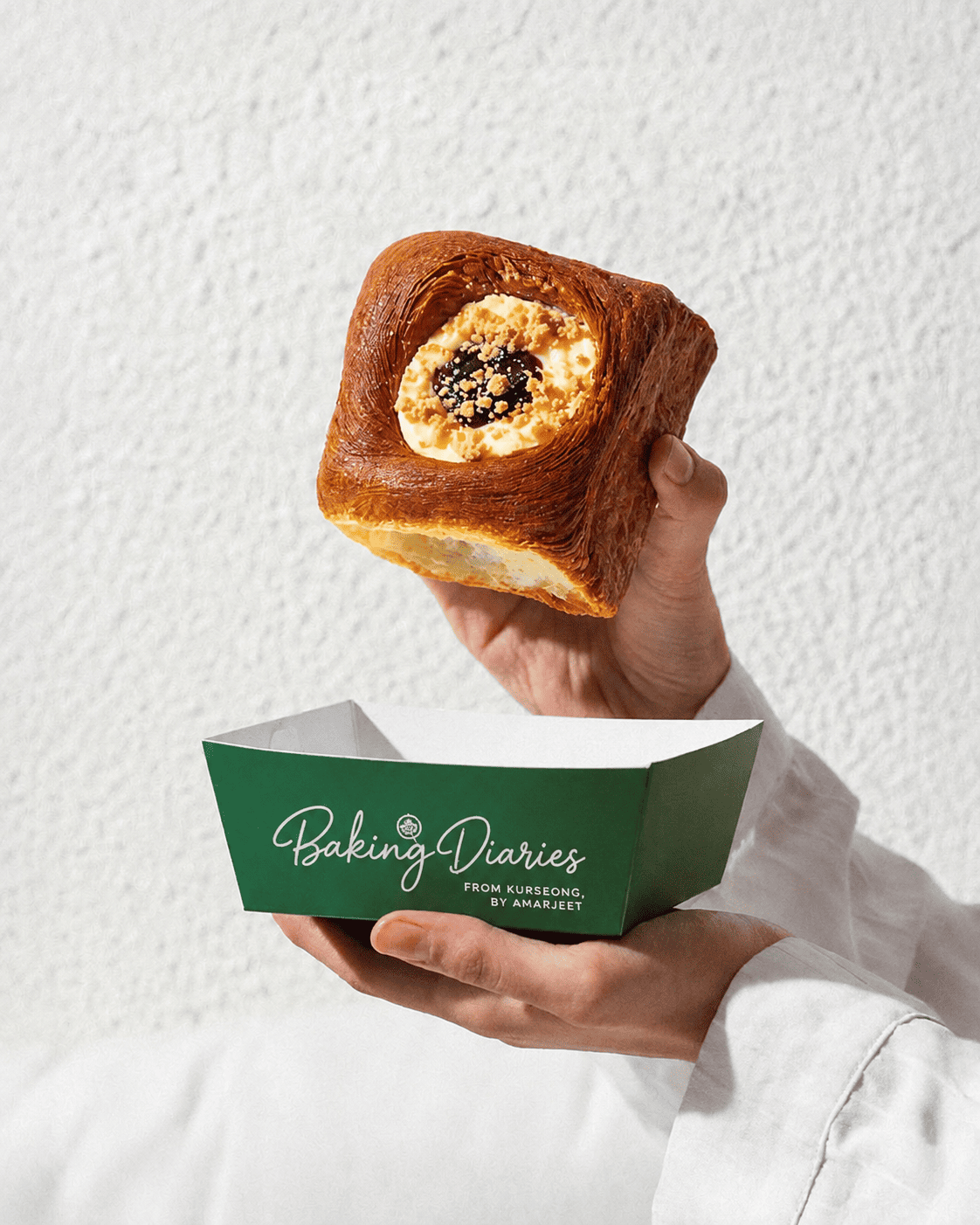 Baking Diaries branded pastry box held in hand